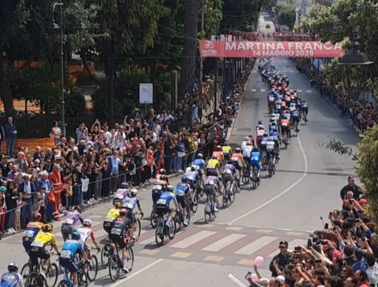 Ciclisti durante il Giro d’Italia a Martina Franca con pubblico festante nel centro storico"